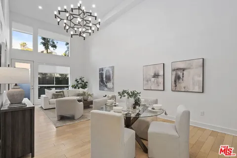 a living room with furniture a chandelier and a flat screen tv
