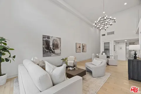 a living room with furniture and a chandelier