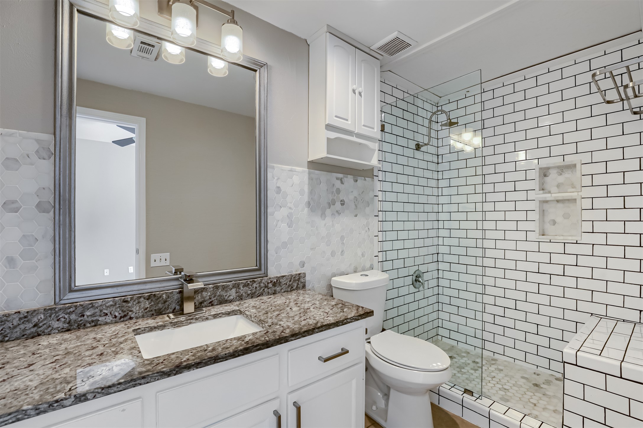 802 South 1st Street, Unit 206 Austin, TX 78704 - Photo 11 of 18 a bathroom with a granite countertop toilet a sink a mirror and shower curtain