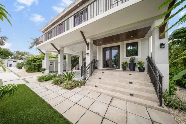 a view of a house with potted plants and a bench