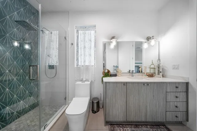 a bathroom with a granite countertop sink toilet and shower