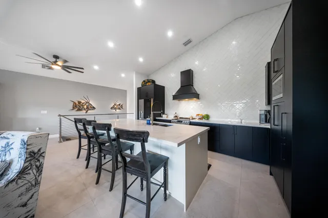 a kitchen with a sink and chairs