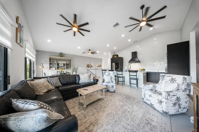 a living room with furniture kitchen view and a flat screen tv
