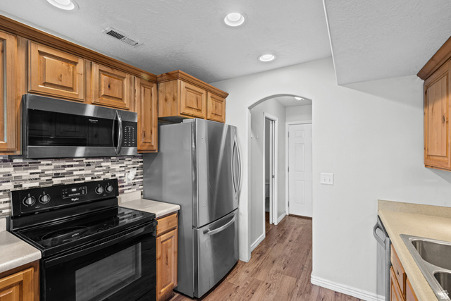 652 West 800 North, Unit 45 Clinton, UT 84015 - Photo 10 of 17 Kitchen featuring wood cabinetry, stainless steel appliances, mosaic tile backsplash, wood-finish flooring, and recessed lighting