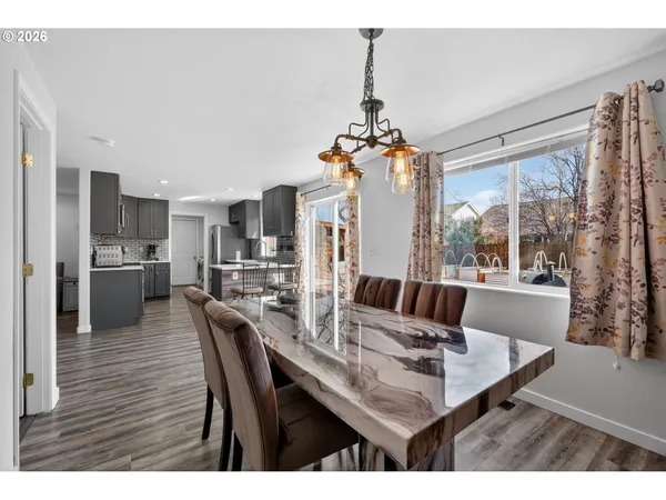 a dining room with furniture a chandelier and wooden floor