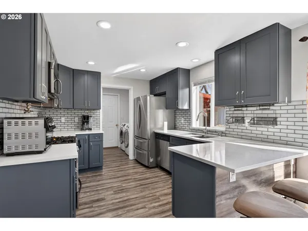a kitchen with stainless steel appliances granite countertop a sink counter space and cabinets