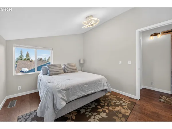 a bedroom with a bed and wooden floor