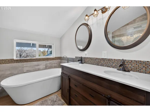 a bathroom with a bathtub a sink and a mirror