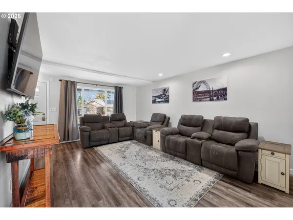 a living room with furniture wooden floor and a flat screen tv