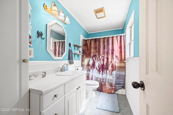 a view of an empty room with a window and a fireplace