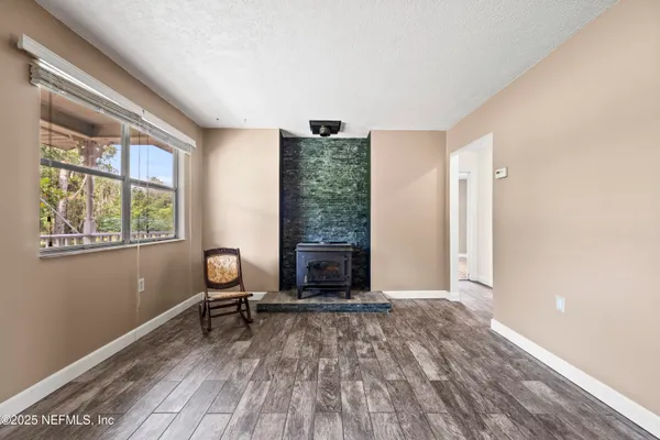 a view of an empty room with furniture and a window