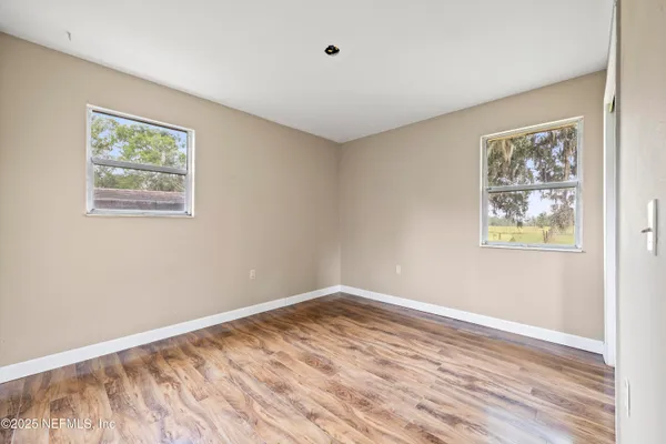 a view of empty room with wooden floor