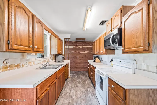 a kitchen with stainless steel appliances a sink stove and cabinets