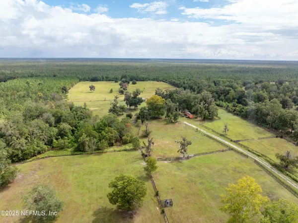 a view of a lake with a yard and large trees