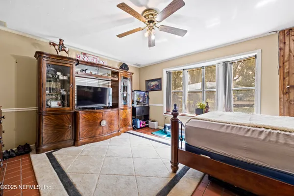 a bedroom with a bed and a flat tv screen on the dresser
