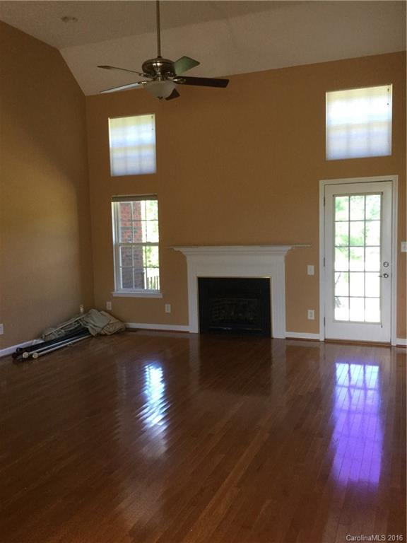 1906 Fletcher Broome Road Monroe, NC 28112 - Photo 8 of 15 an empty room with wooden floor fireplace and windows