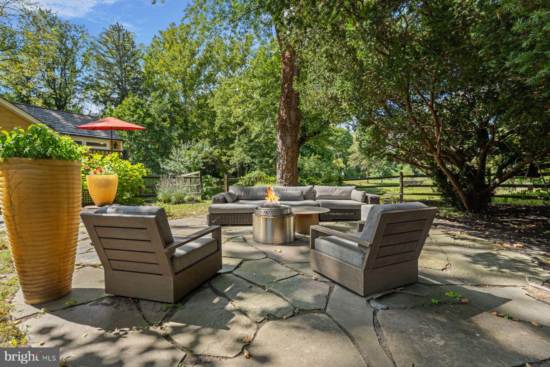 2472 River Road New Hope, PA 18938 - Photo 14 of 50 a view of a patio with table and chairs and a barbeque