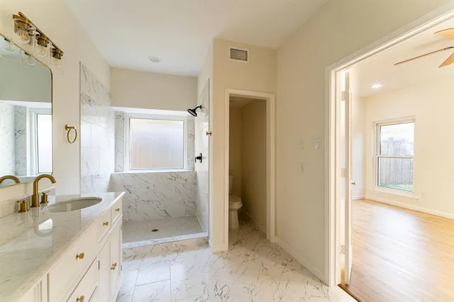 a bathroom with a granite countertop sink mirror and shower