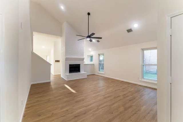 a view of a livingroom with wooden floor and a fireplace