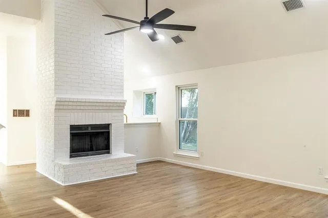 a living room with a fireplace and wooden floor