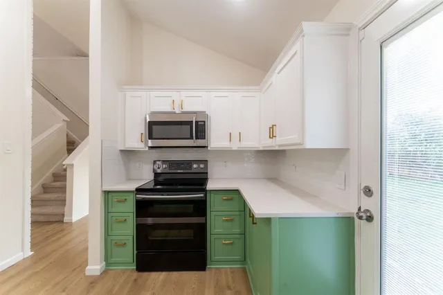 a kitchen with a refrigerator and a stove top oven