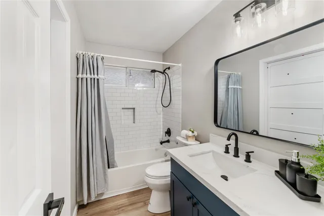 a bathroom with a sink a toilet and shower a mirror