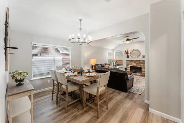 a dining room with furniture a chandelier and wooden floor