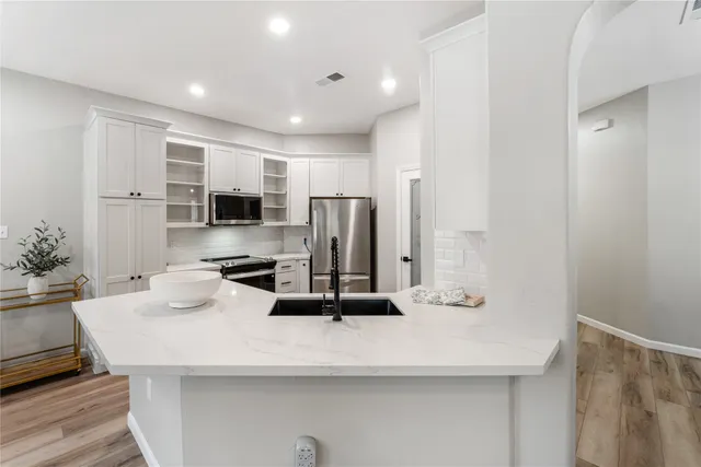 a kitchen with kitchen island a sink stove and refrigerator