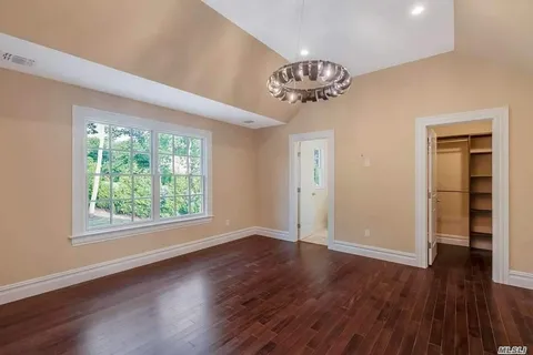 a view of a room with wooden floors and chandelier