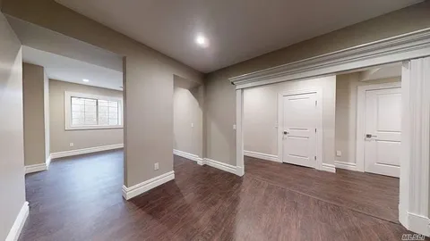 an empty room with wooden floor & windows and bathroom