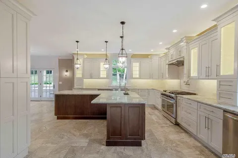 a kitchen with kitchen island granite countertop a sink cabinets and stainless steel appliances
