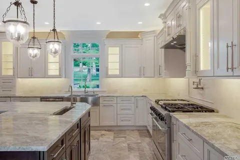 a kitchen with a stove sink and cabinets