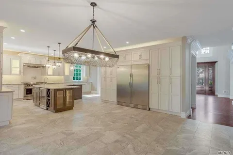 a kitchen with kitchen island a counter top space stainless steel appliances and a chandelier