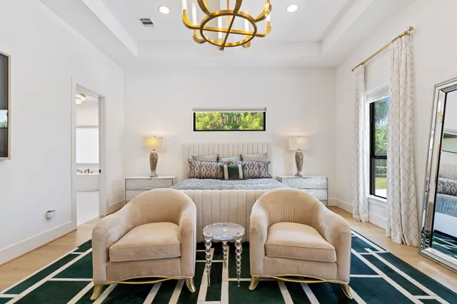 a spacious bedroom with a bed and a chandelier