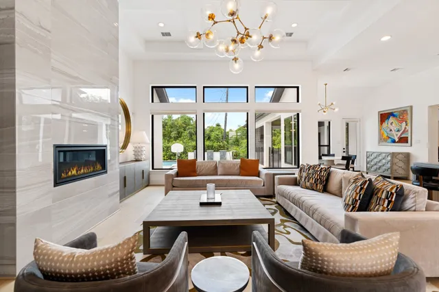 a living room with furniture a chandelier and a fireplace