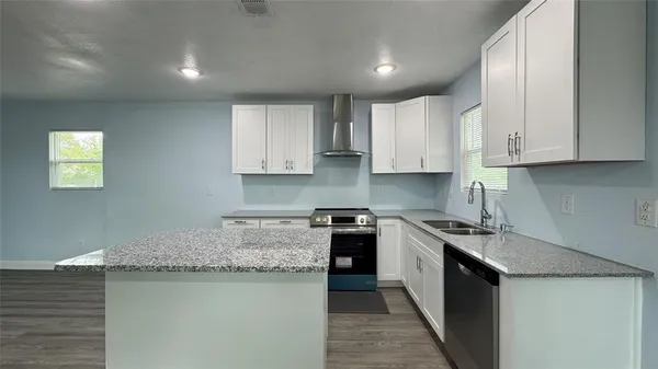 a kitchen with stainless steel appliances granite countertop a sink stove and cabinets