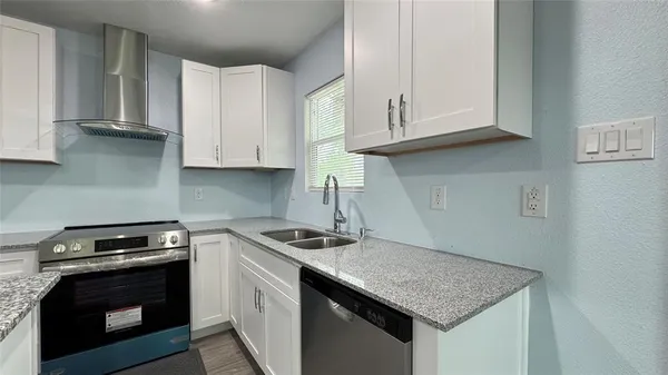a kitchen with stainless steel appliances granite countertop a sink stove and cabinets