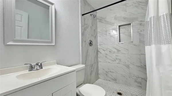 a bathroom with a sink toilet and shower
