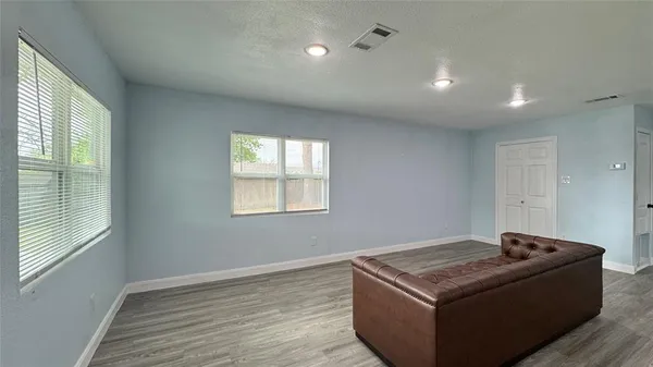 a living room with hard wood floors and a window