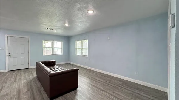 a living room with furniture and a wooden floor