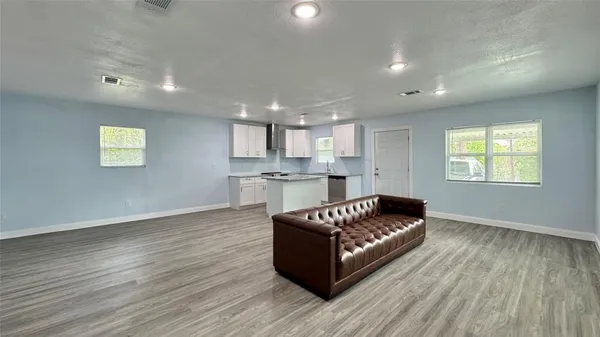 a living room with furniture and a wooden floor