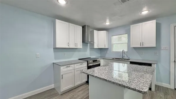 a kitchen with granite countertop white cabinets and white appliances