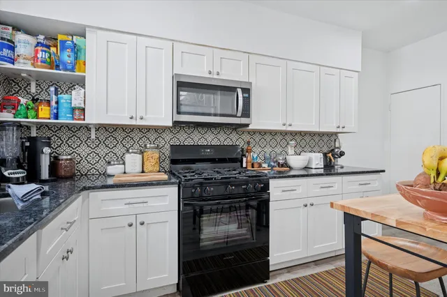 a kitchen with stainless steel appliances a refrigerator a stove a microwave and cabinets