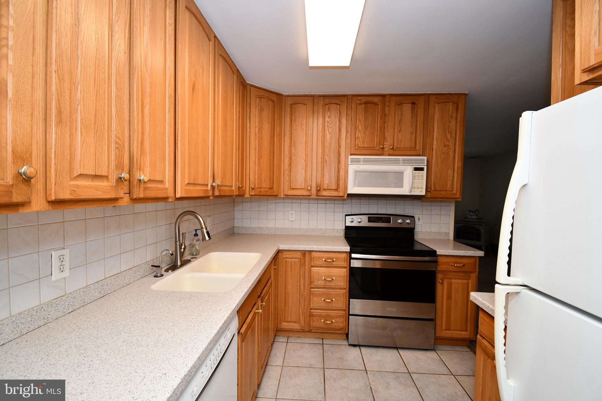 24 Conifer Road Levittown, PA 19057 - Photo 14 of 40 a kitchen with a sink stove and microwave