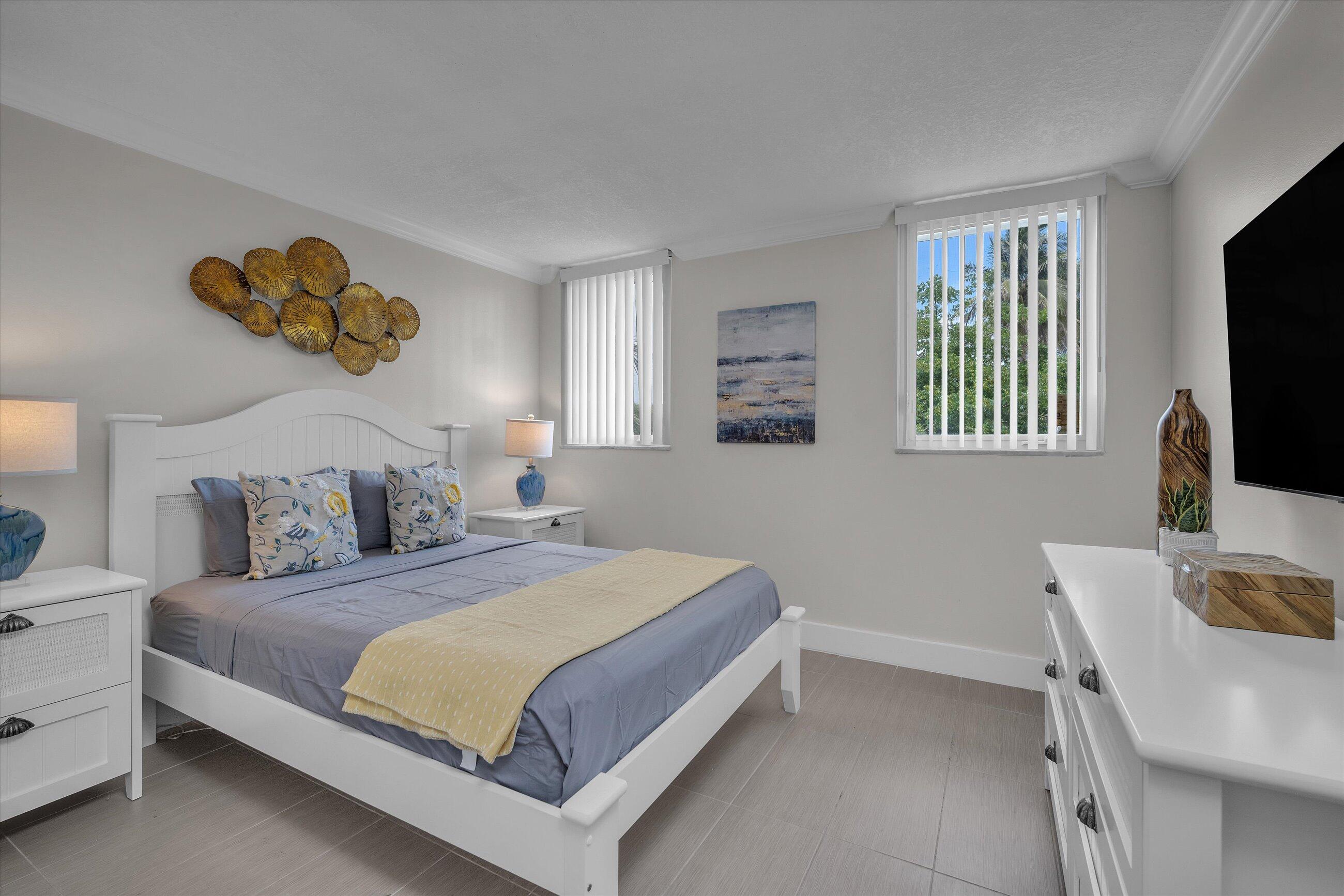 601 North Ocean Boulevard, Unit 203 Boca Raton, FL 33432 - Photo 14 of 20 a bedroom with a bed and a flat screen tv