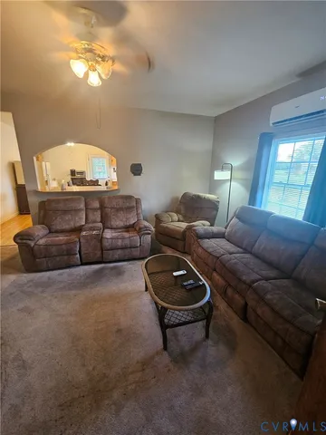 a living room with furniture a lamp and a window