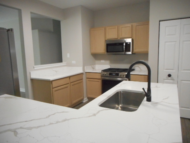 710 Timothy Court East Dundee, IL 60118 - Photo 11 of 25 a kitchen with stainless steel appliances granite countertop a sink a stove and microwave