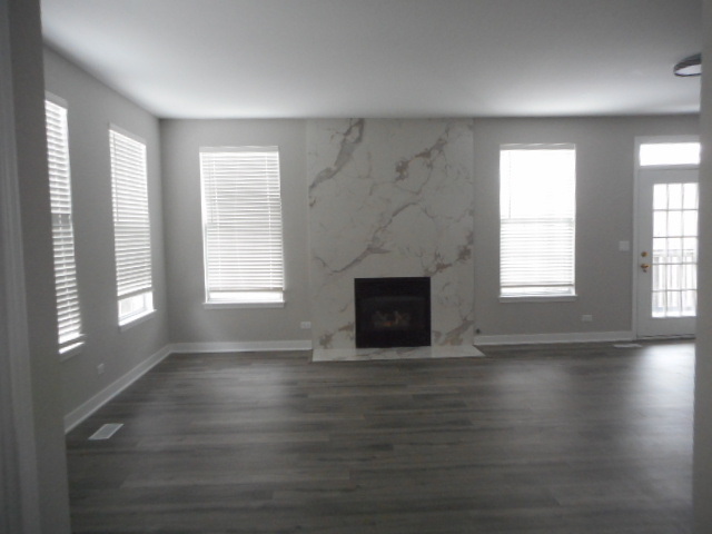 710 Timothy Court East Dundee, IL 60118 - Photo 2 of 25 an empty room with wooden floor fireplace and windows