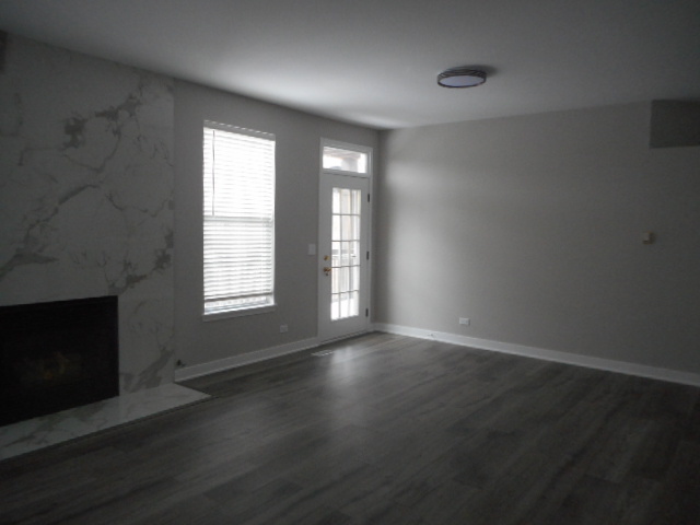710 Timothy Court East Dundee, IL 60118 - Photo 6 of 25 an empty room with wooden floor and fireplace