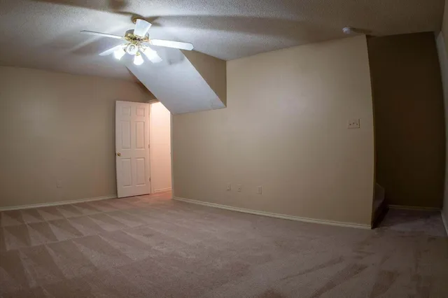an empty room with a chandelier fan